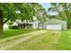 View of the house with attached garage and large front yard with mature trees providing shade at 415 N 3Rd St, Elwood, IN 46036