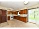 Traditional kitchen features wood cabinetry, white appliances, and sliding doors leading to a patio at 415 N 3Rd St, Elwood, IN 46036