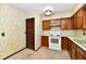 Traditional kitchen features wood cabinetry and white appliances at 415 N 3Rd St, Elwood, IN 46036