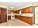 Traditional kitchen features wood cabinetry, white appliances, and sliding doors leading to a patio at 415 N 3Rd St, Elwood, IN 46036