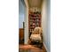 Hallway area with decorative bookshelf, chair, and views into the adjacent rooms at 4305 W Coyote Run Ct, Muncie, IN 47304