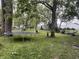 Large backyard with green grass, mature trees, a trampoline, and a hammock at 4521 Vernon Ave, Indianapolis, IN 46226