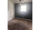 Bedroom featuring brown carpet, a dark wall, and a window with natural light coming through at 4521 Vernon Ave, Indianapolis, IN 46226