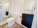 Modern half bathroom with a glass-top vanity and a large mirror at 4635 Stansbury Ct, Indianapolis, IN 46254