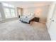Bright main bedroom with a large window, soft carpet, and warm sconce lighting at 4635 Stansbury Ct, Indianapolis, IN 46254