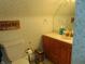 Cozy bathroom with a toilet, vanity, mirror, and floral-patterned walls at 4747 Guion Rd, Indianapolis, IN 46254