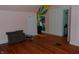 Bedroom featuring hardwood floors, colorful mural and soft natural light from the window at 4747 Guion Rd, Indianapolis, IN 46254