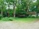 Exterior view of a cottage home surrounded by lush greenery and mature trees at 4747 Guion Rd, Indianapolis, IN 46254