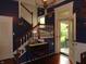 Foyer with dark blue walls, stained staircase and vintage glass at entry at 4747 Guion Rd, Indianapolis, IN 46254
