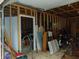 Unfinished garage interior featuring exposed wooden beams and some stored personal items, and access to an adjacent room at 4747 Guion Rd, Indianapolis, IN 46254
