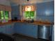 Bright kitchen boasts plenty of counter space with butcher block countertops, painted cabinets and a stainless steel dishwasher at 4747 Guion Rd, Indianapolis, IN 46254