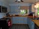 Charming kitchen features painted cabinets, butcher block countertops and a view of the backyard through the window at 4747 Guion Rd, Indianapolis, IN 46254