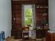 A built-in desk and shelves fill a well-lit office space with a window and wood accents at 4747 Guion Rd, Indianapolis, IN 46254