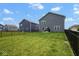 Grassy backyard with a black wrought iron fence and a view of the home's rear elevation at 4832 W Safford Dr, New Palestine, IN 46163