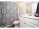 Updated bathroom with blue patterned curtain, toilet and modern white vanity with chrome faucet at 4832 W Safford Dr, New Palestine, IN 46163
