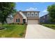 Inviting two-story home showcasing a brick facade, gray siding, neat landscaping, and a spacious driveway at 4832 W Safford Dr, New Palestine, IN 46163