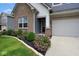 Close-up of a home's exterior, highlighting brick accents, siding, and neatly trimmed landscaping at 4832 W Safford Dr, New Palestine, IN 46163