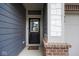 Welcoming front entrance featuring a black door with window, accented by brick and modern siding at 4832 W Safford Dr, New Palestine, IN 46163