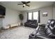 Comfortable living room with a ceiling fan, featuring leather seating, a plant, and natural light from the windows at 4832 W Safford Dr, New Palestine, IN 46163