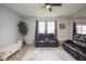 Bright living area featuring leather sofas, a rug, and a tall plant near the windows at 4832 W Safford Dr, New Palestine, IN 46163