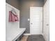 Mudroom with white hall tree bench seating, coat hooks, and gray accent wall at 4832 W Safford Dr, New Palestine, IN 46163