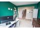 Home office with green accent wall, white desk, and stairway in background at 4832 W Safford Dr, New Palestine, IN 46163