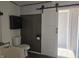 Bathroom featuring a toilet, sink, barn door, modern fixtures and a mounted cabinet at 496 Tague St, Greenfield, IN 46140
