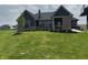 The exterior view of a home with lush green lawn, dark siding and brick accents at 4995 S 650 W, Jamestown, IN 46147