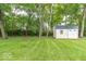 Backyard with a shed, green grass, and mature trees at 5104 W Prairiewood Dr, Muncie, IN 47304