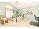 Light and airy bedroom with ceiling fan, large window, and rocking chair at 5104 W Prairiewood Dr, Muncie, IN 47304