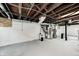 Unfinished basement area with painted walls, exposed ceiling joists, and equipment at 5203 Carrollton Ave, Indianapolis, IN 46220