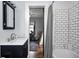 Updated bathroom features white tile, black vanity, modern mirror, and views to the bedroom at 5203 Carrollton Ave, Indianapolis, IN 46220