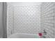 Updated bathroom with white tile surround on tub and shower with chrome fixtures at 5203 Carrollton Ave, Indianapolis, IN 46220