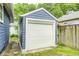 Exterior view of detached garage with white door and blue siding at 5203 Carrollton Ave, Indianapolis, IN 46220