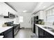 Modern kitchen featuring sleek white cabinets, stainless steel appliances, and tiled floors at 5203 Carrollton Ave, Indianapolis, IN 46220