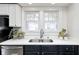 Bright kitchen features stainless steel sink, modern faucet, white countertops and black cabinets at 5203 Carrollton Ave, Indianapolis, IN 46220