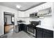 Bright kitchen with stainless steel appliances, white cabinets, and hardwood floors in adjacent rooms at 5203 Carrollton Ave, Indianapolis, IN 46220