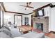 Spacious living room featuring a brick fireplace, hardwood floors, and a comfortable gray sectional at 5203 Carrollton Ave, Indianapolis, IN 46220