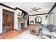 Comfortable living room with hardwood floors, a brick fireplace, and a gray sectional couch at 5203 Carrollton Ave, Indianapolis, IN 46220