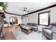 Bright living room with hardwood floors, a gray sectional, and a view into the dining area at 5203 Carrollton Ave, Indianapolis, IN 46220