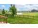 Backyard with a well-maintained lawn, wrought iron fence, and a serene water view at 5439 Maywood Dr, Whitestown, IN 46075
