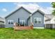 Rear elevation of home with a deck, spacious yard, and lovely outdoor space at 5439 Maywood Dr, Whitestown, IN 46075