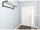 Clean entryway featuring light gray walls, gray laminate flooring, coat rack and a white front door with side window at 5439 Maywood Dr, Whitestown, IN 46075