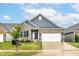 Charming single-Gathering home with a gray brick facade, blue siding and a well-manicured lawn and a two car garage at 5439 Maywood Dr, Whitestown, IN 46075