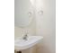 Close up of a pedestal sink and round mirror in a well-lit bathroom, complemented by modern fixtures at 565 Cembra Dr, Greenwood, IN 46143