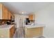 Modern kitchen with stainless appliances, wooden cabinetry, and an eat-in bar area at 565 Cembra Dr, Greenwood, IN 46143