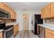Modern kitchen with stainless appliances, wooden cabinetry, view of laundry room and modern flooring at 565 Cembra Dr, Greenwood, IN 46143