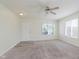 Bright and open living room with neutral carpet, large window, and a white front door at 565 Cembra Dr, Greenwood, IN 46143