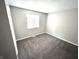 Neutral bedroom featuring plush carpeting, freshly painted walls, and a window offering natural light at 5826 Buck Rill Dr, Indianapolis, IN 46237