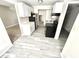 Galley style kitchen with white cabinets, stainless steel refrigerator and black appliances at 5826 Buck Rill Dr, Indianapolis, IN 46237